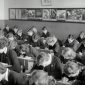 grayscale photo of people sitting on chair